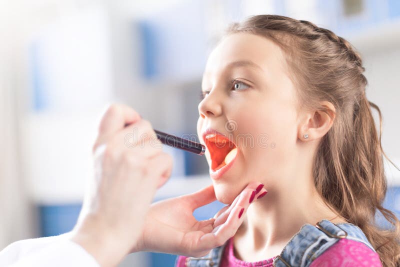 Woman doctor checking throat of little girl stock photography Woman doctor checking throat of little girl stock photography