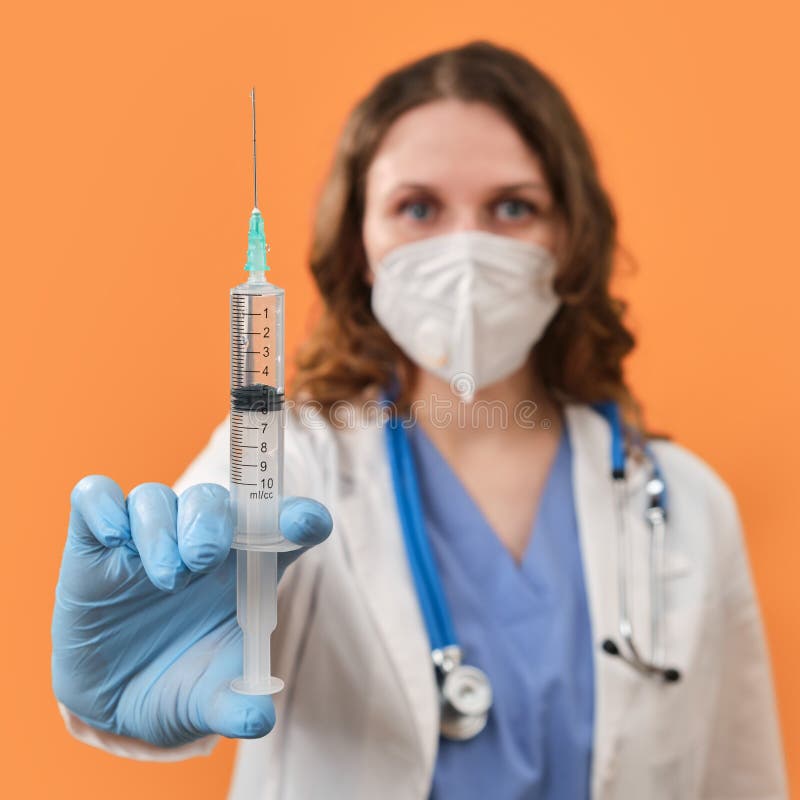 Woman Doctor Holds Syringes In His Hand On A Red Background Concept Female Nurse With Syringes