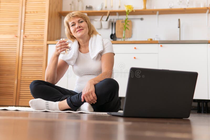 A middle-aged woman does fitness in a bright room