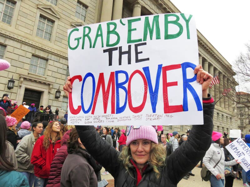 Photo of women protester bearing a large sign at the women`s march on 1/21/17 in washington dc. Donald trump was elected president to a divided country. This march drew over 1 million people with most of them being women. Photo of women protester bearing a large sign at the women`s march on 1/21/17 in washington dc. Donald trump was elected president to a divided country. This march drew over 1 million people with most of them being women.