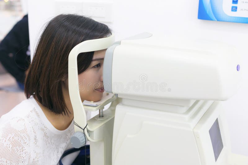 Woman doing eye test with optometrist machine in eye sight clinic. stock images Woman doing eye test with optometrist machine in eye sight clinic. stock images