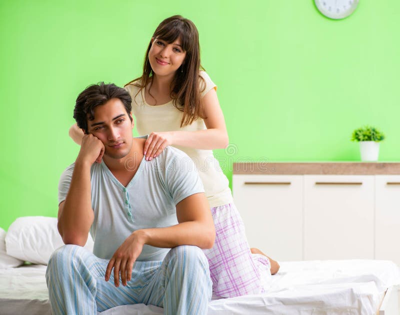 Woman Doing Massage To Her Husband In Bedroom Stock Ph image