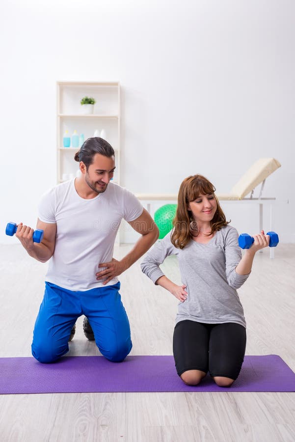 Young Woman Doing Sport Exercises with Personal Coach Stock Photo