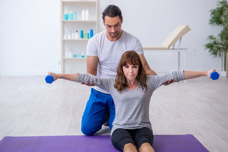 Young Woman Doing Sport Exercises with Personal Coach Stock Photo