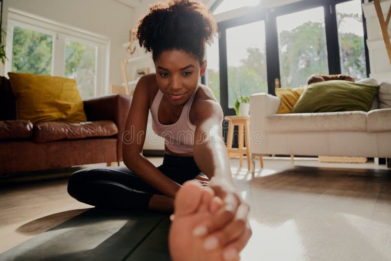 Closeup portrait of african woman doing warm-up exercise before workout at home stock photo