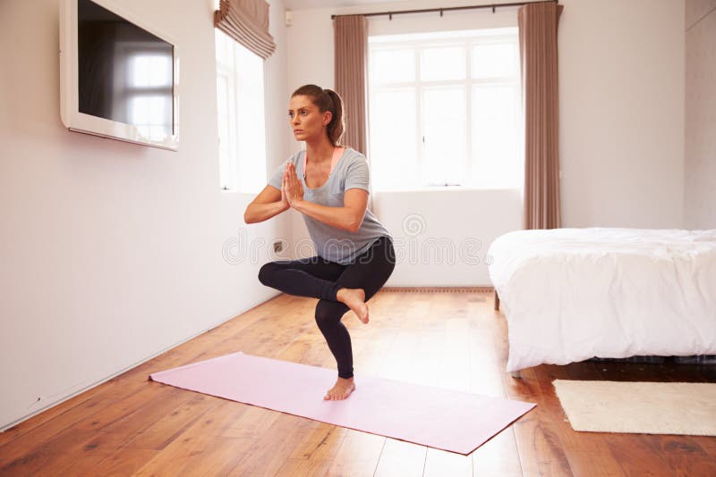 Woman Doing Yoga Fitness Exercises On Mat In Bedroom Stock Image