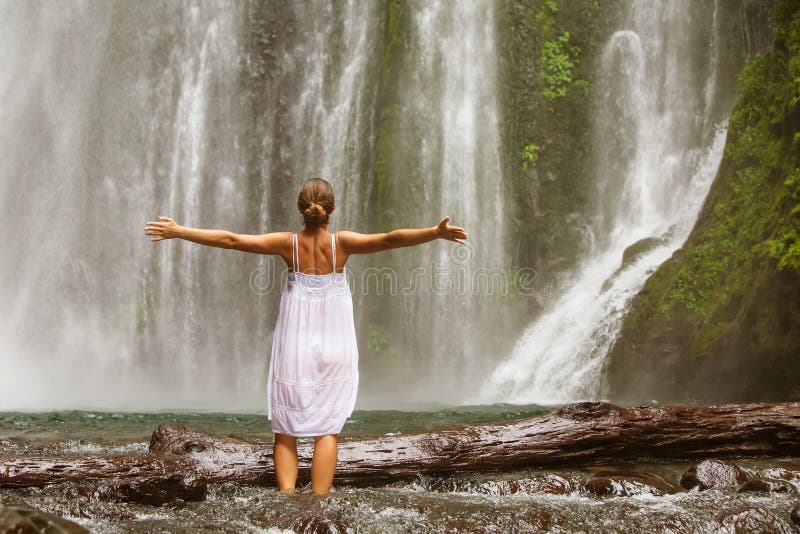 Woman doing yoga near waterfall