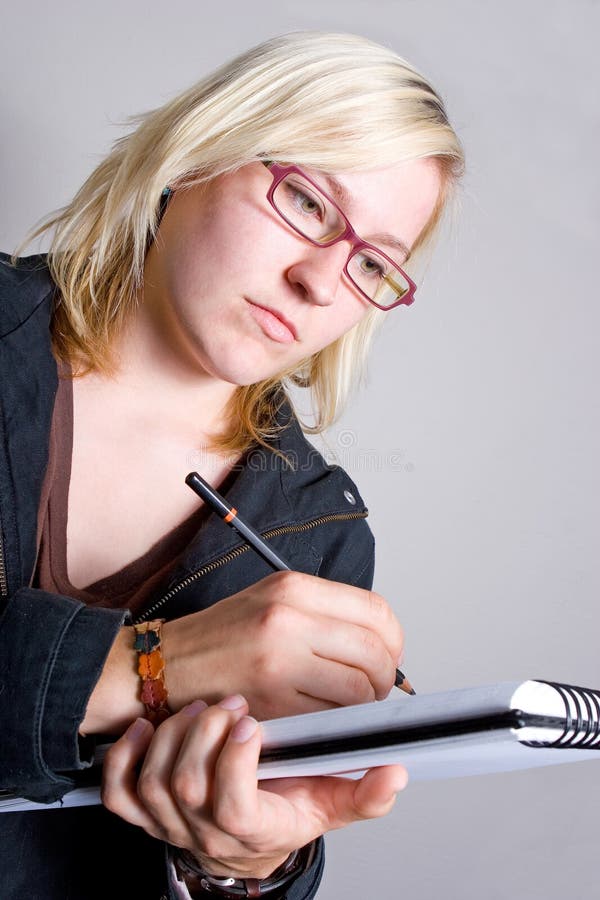 Modern young blond woman taking notes/drawing on a notepad. Can be used as a business or artistic environment. Modern young blond woman taking notes/drawing on a notepad. Can be used as a business or artistic environment.