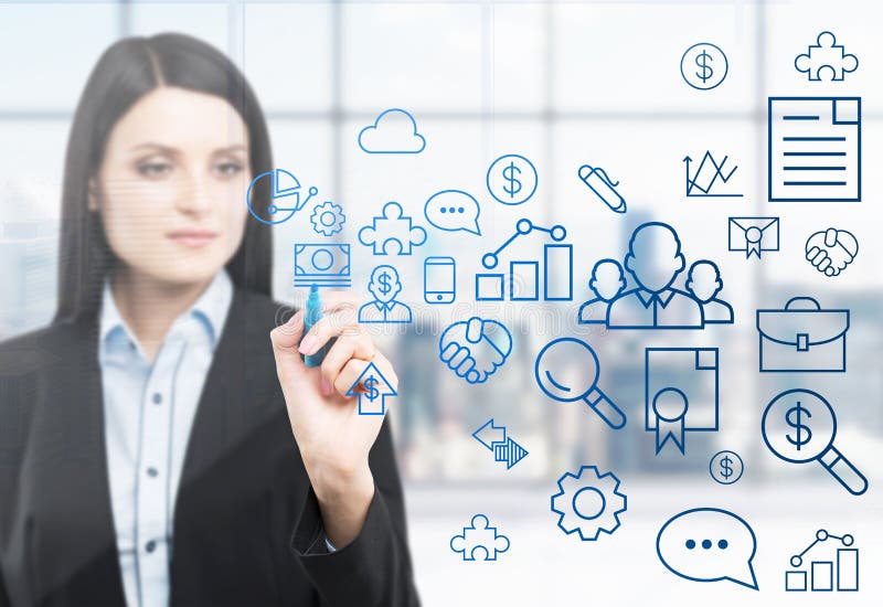 A woman is drawing some business icons on the glass screen. Modern panoramic office with New York view in blur on the bac stock image A woman is drawing some business icons on the glass screen. Modern panoramic office with New York view in blur on the bac stock image