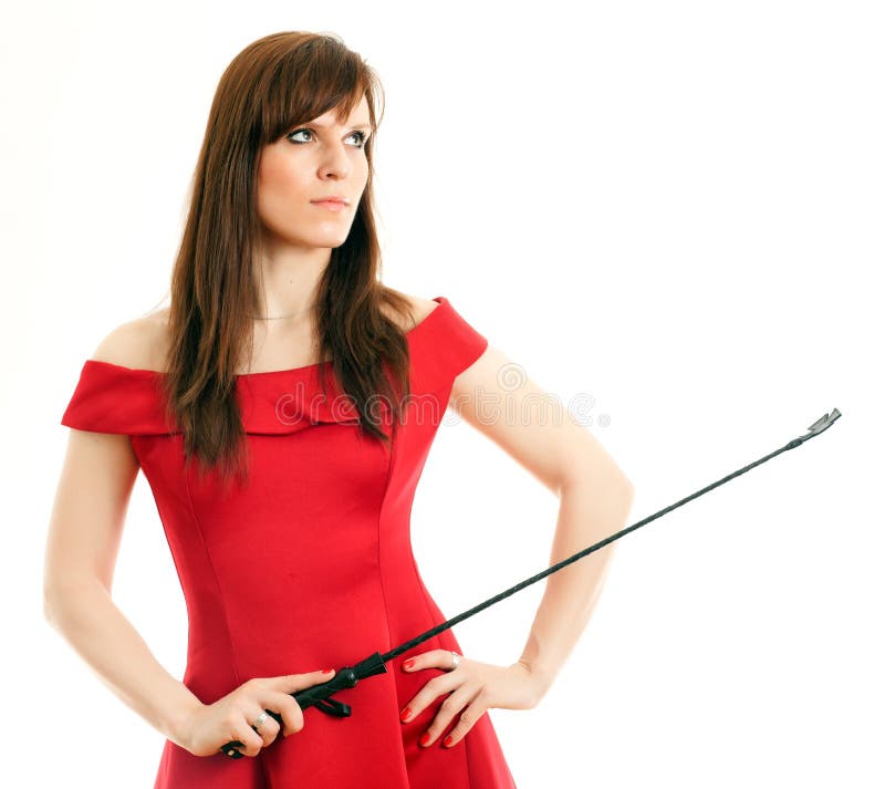 Beautiful woman in a red dress holding a riding crop on white background.