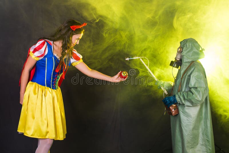 Woman dressed as fairytale character holds Radioactive atomic nuclear ionizing radiation danger warning symbol on apple. Girl dressed as fairytale character stock images Woman dressed as fairytale character holds Radioactive atomic nuclear ionizing radiation danger warning symbol on apple. Girl dressed as fairytale character stock images