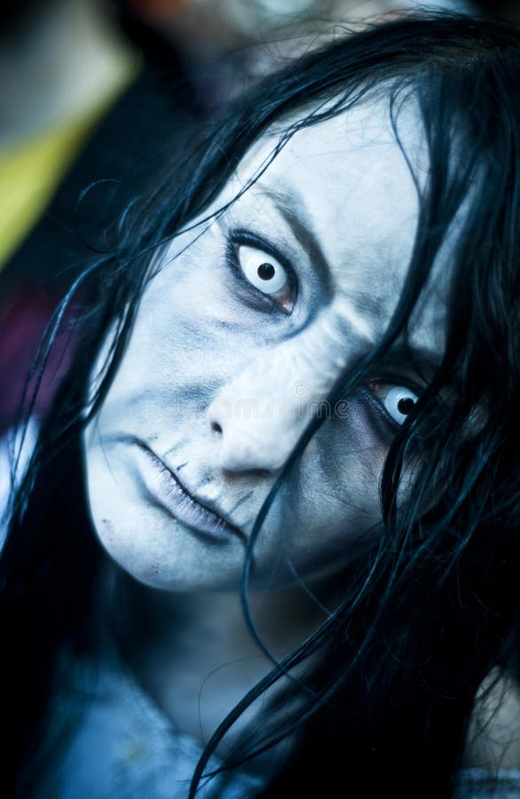 Woman dressed as a zombie parades on a street during a zombie walk