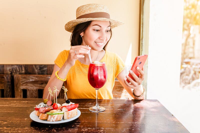 Woman drink sangria and eating tapas in spanish cafe