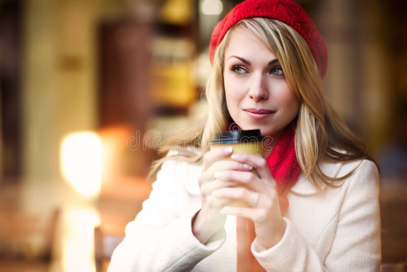 A shot of a beautiful caucasian woman drinking coffee at a cafe