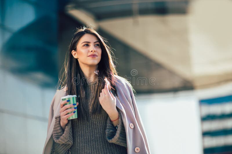 Woman drinking coffee to go in a city street stock image Woman drinking coffee to go in a city street stock image