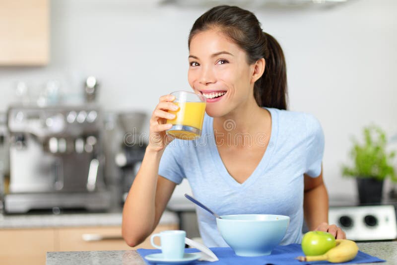 Woman drinking orange juice eating breakfast stock photo Woman drinking orange juice eating breakfast stock photo
