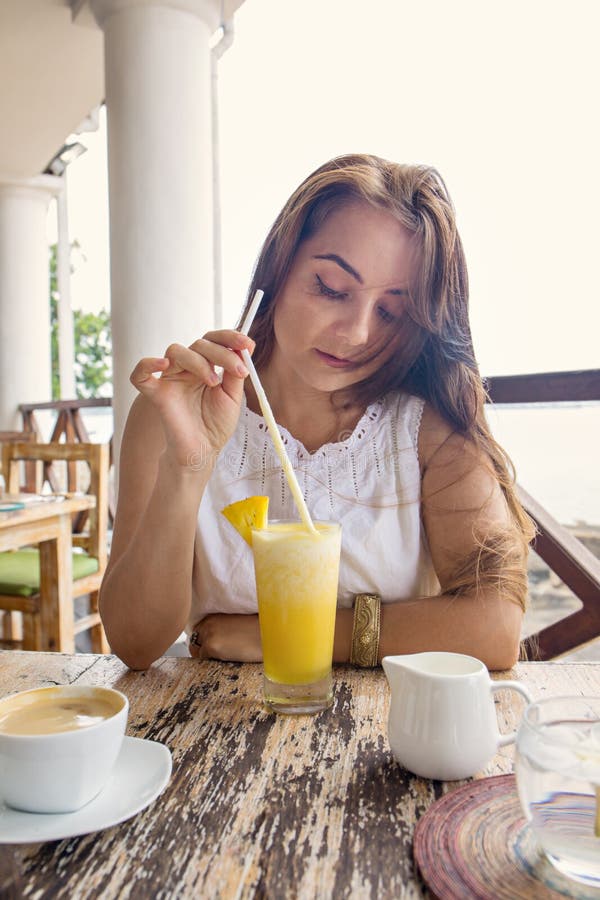 Woman drinking pineapple juice.