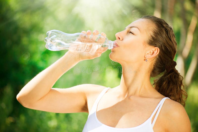 Sano, Sportivo e Giovane Donna che beve l'Acqua della bottiglia.