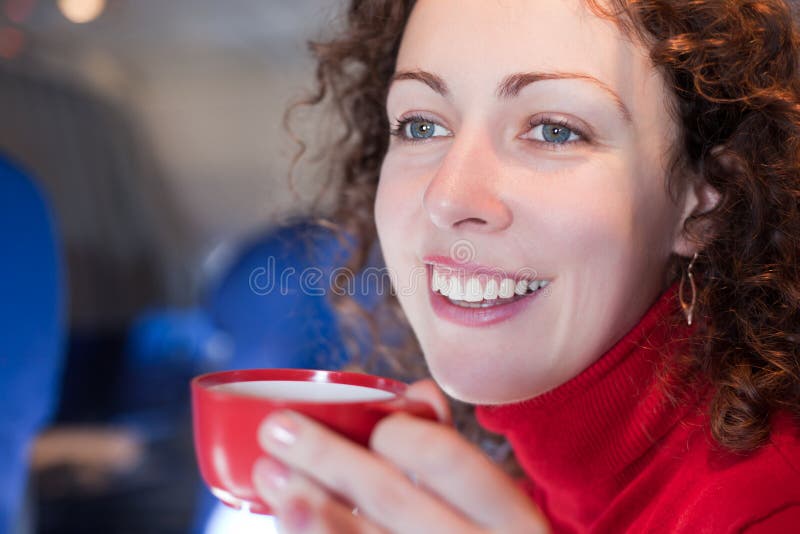 Woman drinks coffee from cup on airplane