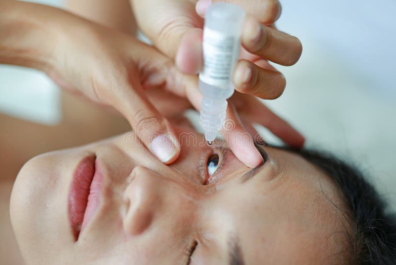 Woman dripping eye with eyes drops