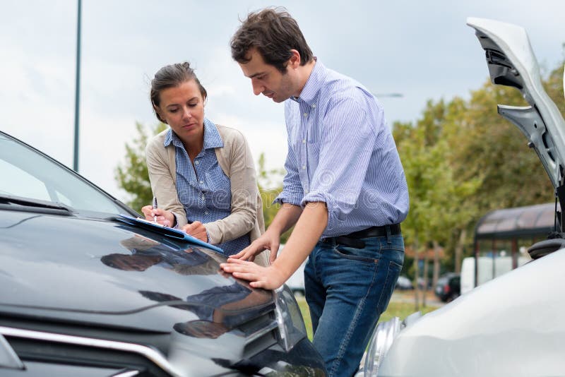 Woman driver and man reporting the damage of the car after accident stock photography Woman driver and man reporting the damage of the car after accident stock photography