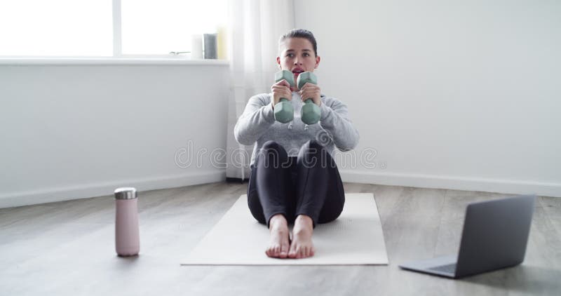 Woman, dumbbell and weight lifting for exercise with laptop, breathing and yoga mat in living room of home. Person, face