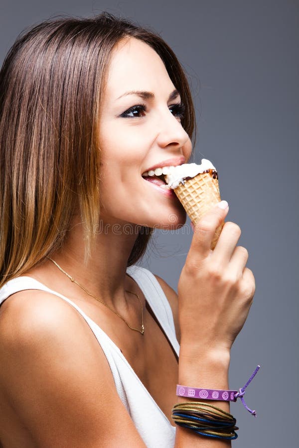 Young happy woman eat icecream, studio shot