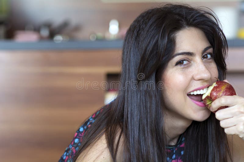 Woman eating apple smiling happy looking at camera. royalty free stock images Woman eating apple smiling happy looking at camera. royalty free stock images