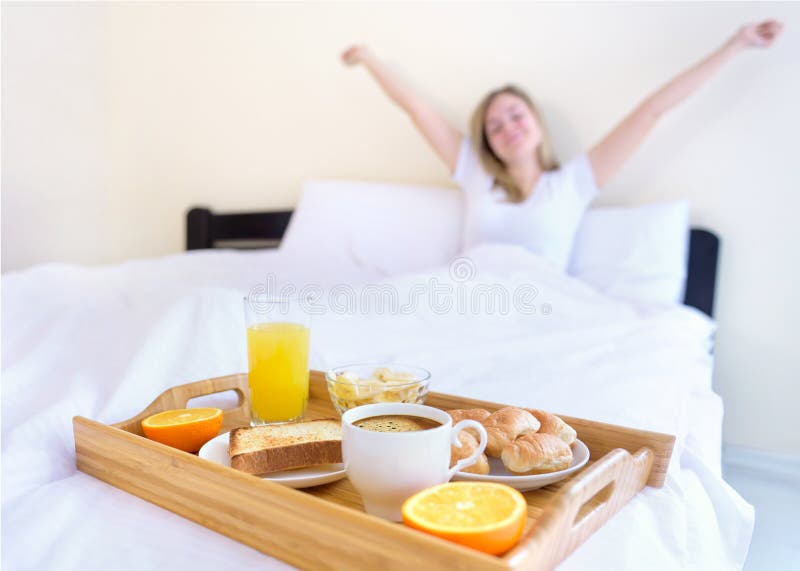 Woman eating breakfast in bed stock images.