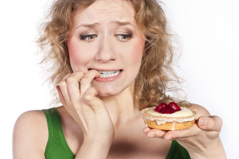 Woman eating a cake. In studio