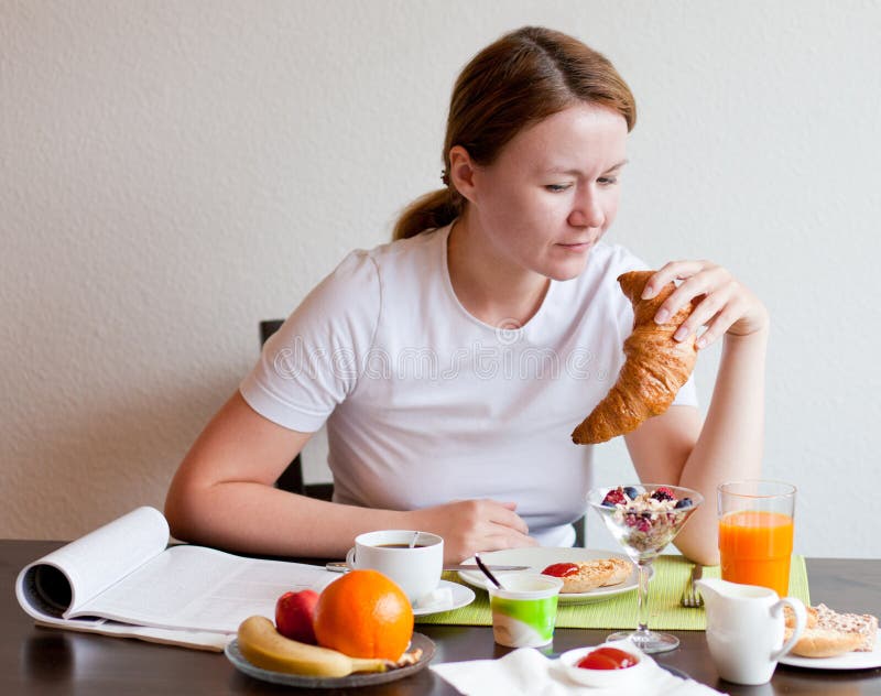 Woman eating croissant