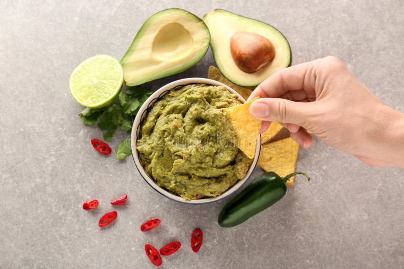 Woman eating delicious guacamole with nachos, closeup stock image