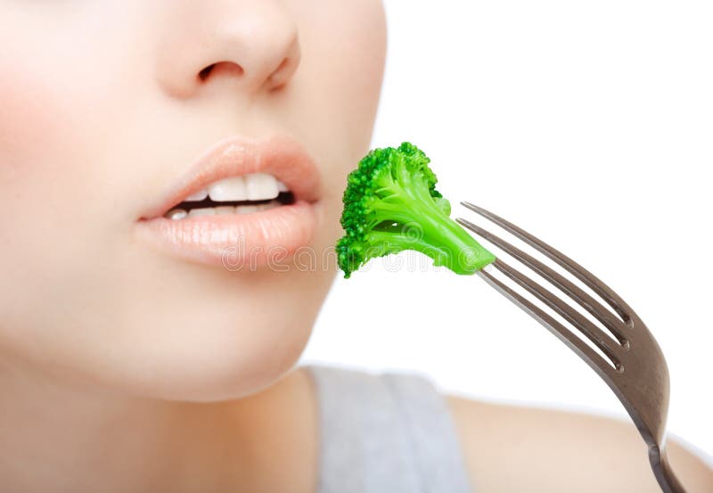 Woman eating green broccoli