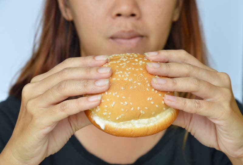 Woman eating hamburger dressing ketchup royalty free stock image