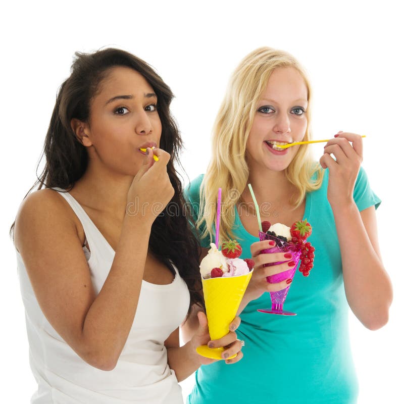 Black and white women eating ice cream with fresh fruit isolated over white background. Black and white women eating ice cream with fresh fruit isolated over white background