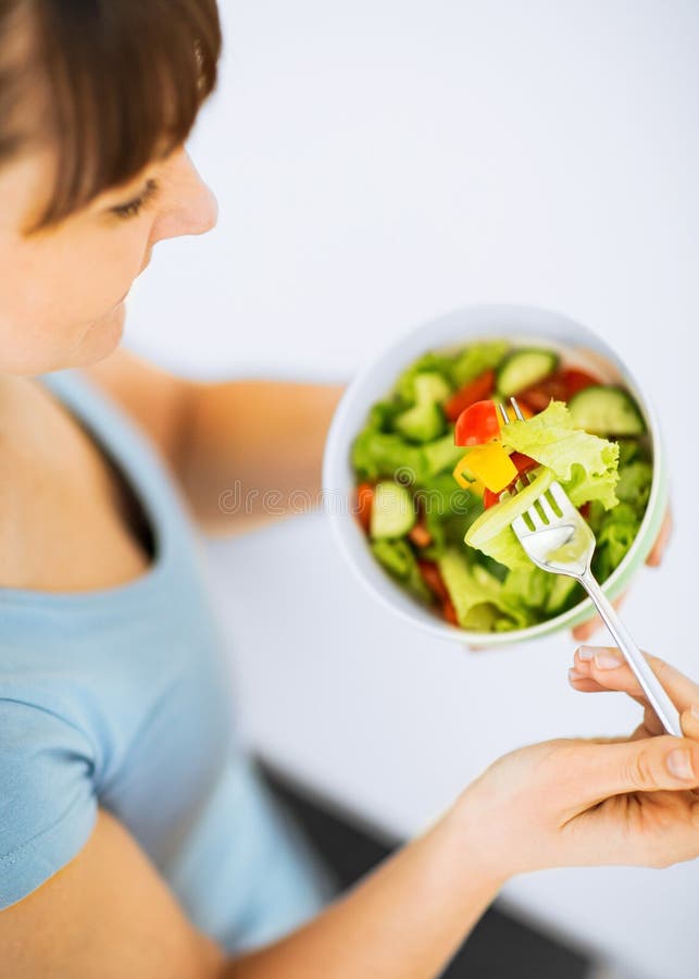 Woman eating salad with vegetables