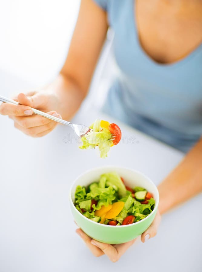 Woman eating salad with vegetables