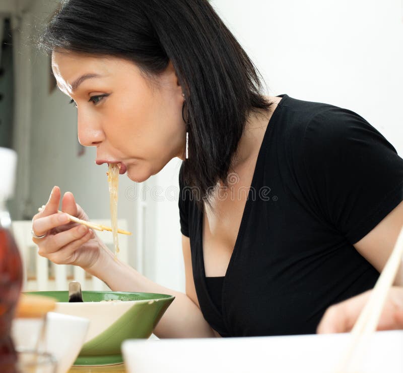 Transgender LGBT Asian Woman eats spicy hot tomyum noodle soup and hanging on chopstick to mouth with sweat delicious enjoy eating