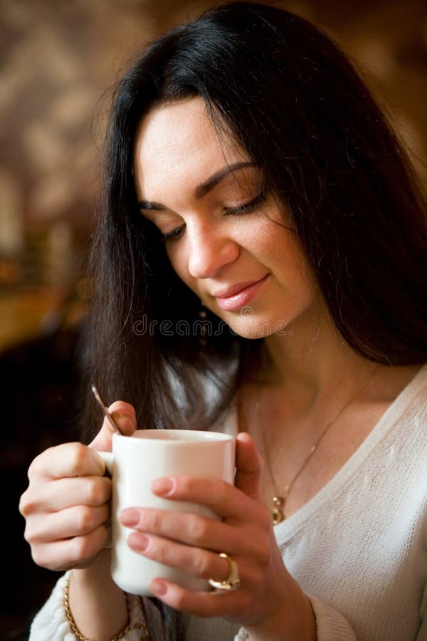 Woman enjoying latte coffee in caf