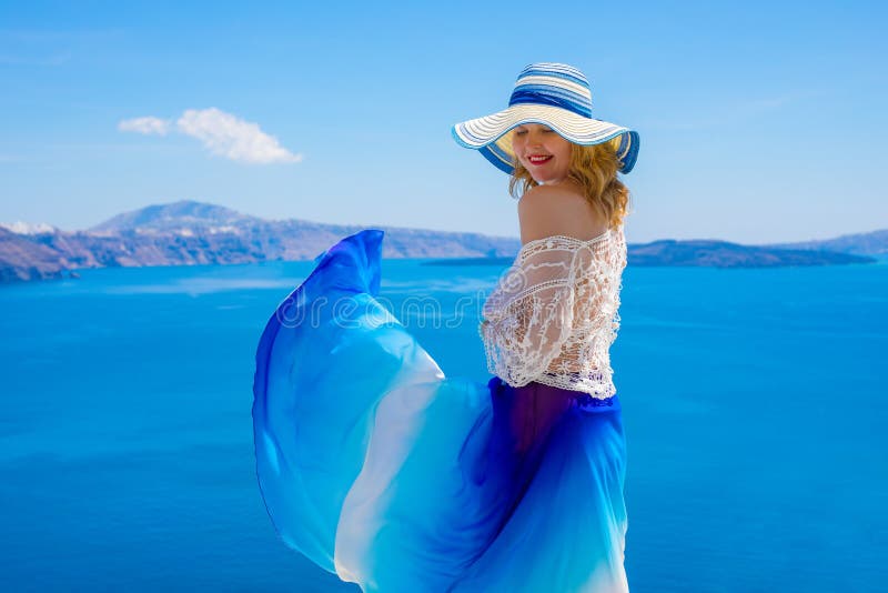 Woman enjoying warm summer weather with blue skirt blowing in the wind