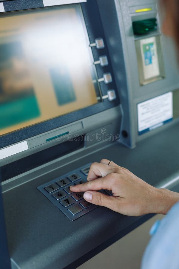 Woman entering pin-code in ATM stock photos