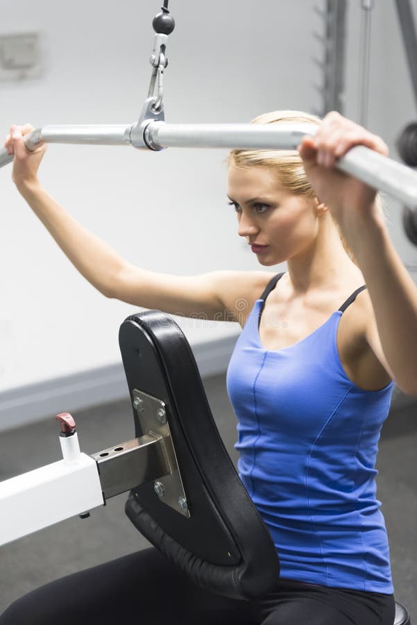 Woman Looking Away While Exercising On Fitness Ball At Gym Stock Photo ...