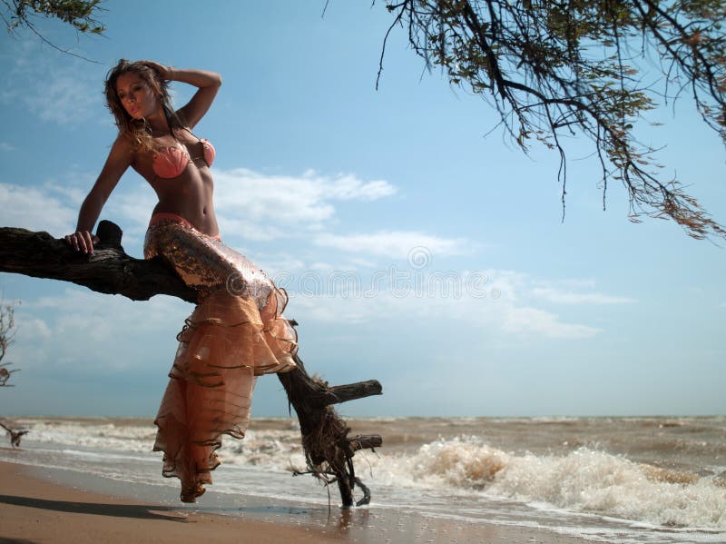 Woman in exotic dress sitting on a branch