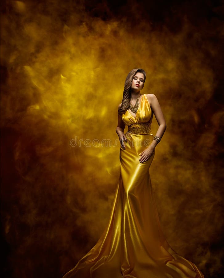 Woman Fashion Model Gold Dress, Beauty Girl in Glamour Gown posing on Golden artistic background