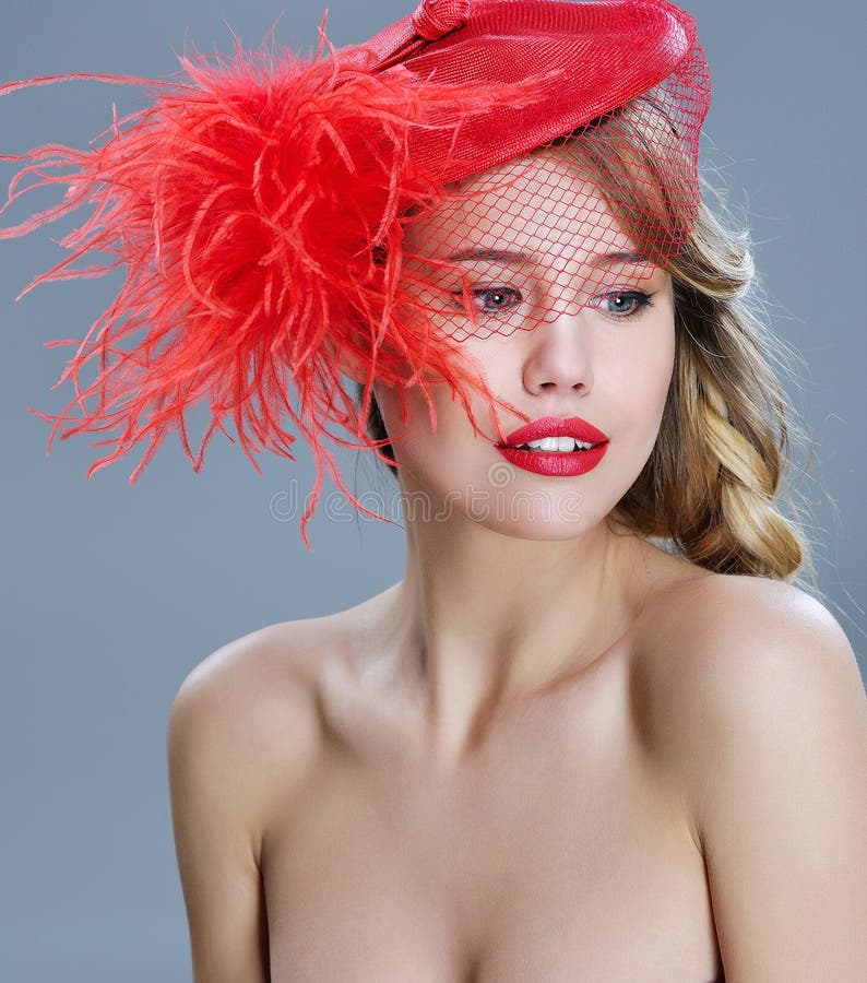 Woman fashion portrait in red vintage hat with feathers