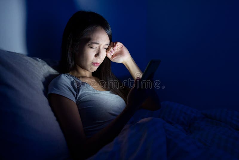 Woman feeling tired with using mobile phone on bed ,asian young woman