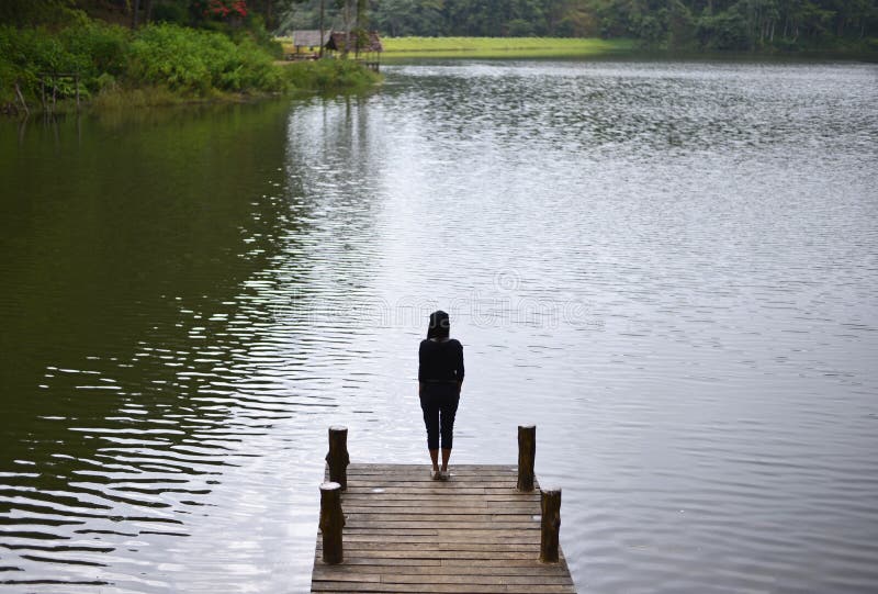Woman feeling victorious facing on the bridge in the lake, royalty free stock photos Woman feeling victorious facing on the bridge in the lake, royalty free stock photos
