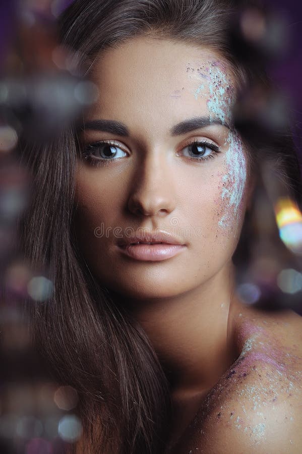 Beautiful woman with festive makeup in color spray and boke lights. Beautiful woman with festive makeup in color spray and boke lights
