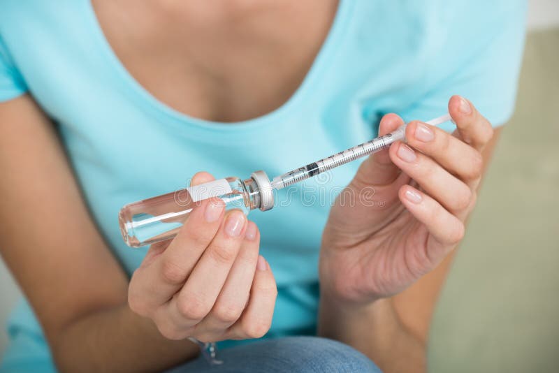 Woman Filling Medicine In Syringe