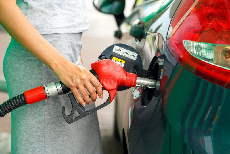 Woman fills petrol into the car at a gas station. Benzine, petroleum.